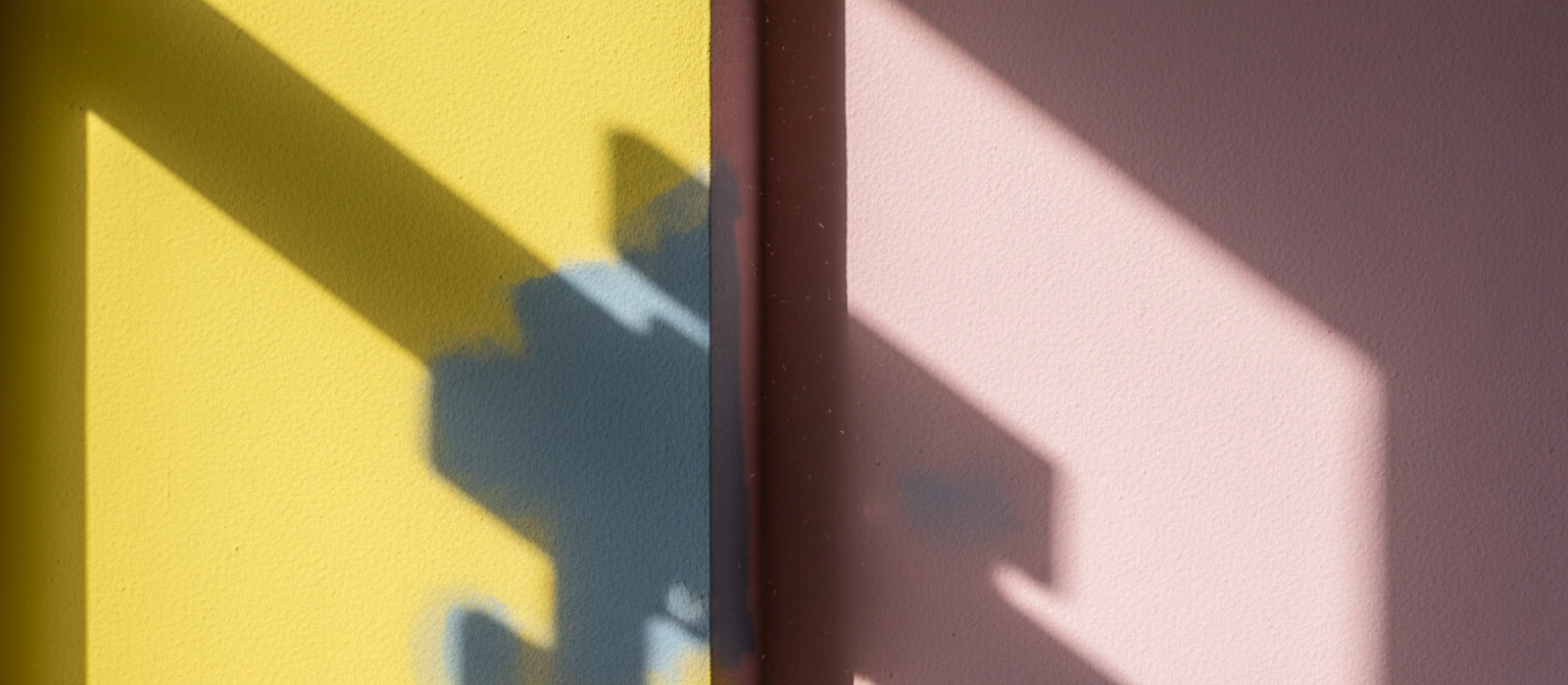 Detail shot of a corner where a bright yellow wall meets a pink wall