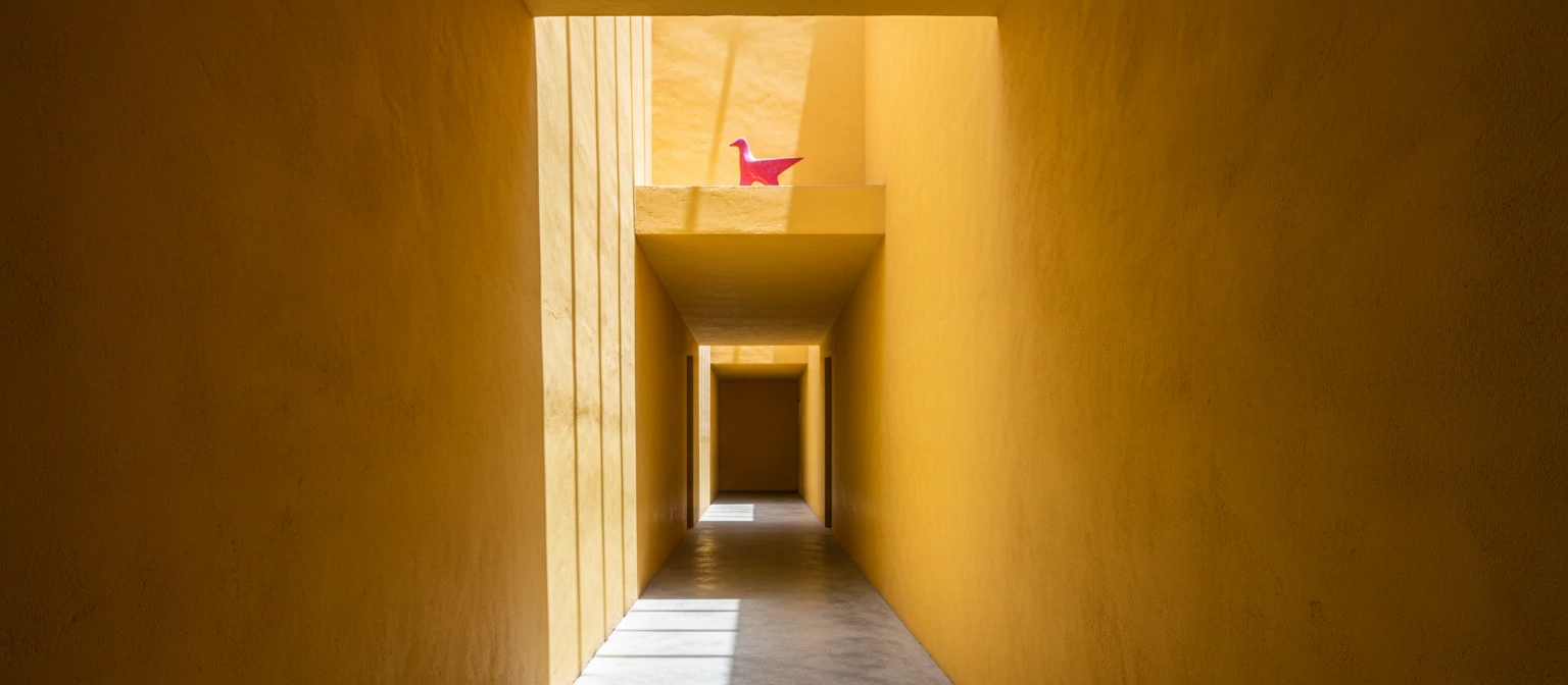 Yellow illuminated corridor in Casa Gilardi designed by Luis Barragán